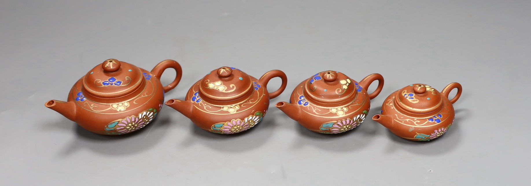 Four Chinese Yixing graduated enamelled miniature teapots, largest 5.5cms high
